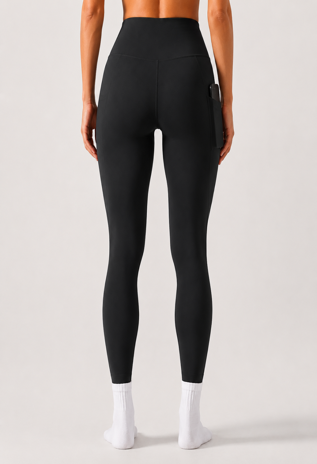 Person wearing black leggings on a plain background
